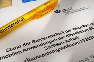Deckblatt des Berichts mit dem Titel „Stand der Barrierefreiheit der Websites und mobilen Anwendungen der öffentlichen Stellen in Sachsen-Anhalt: Überwachungszeitraum 2020/2021“. Darauf liegt ein gelber Kugelschreiber mit dem Wort „barrierefrei