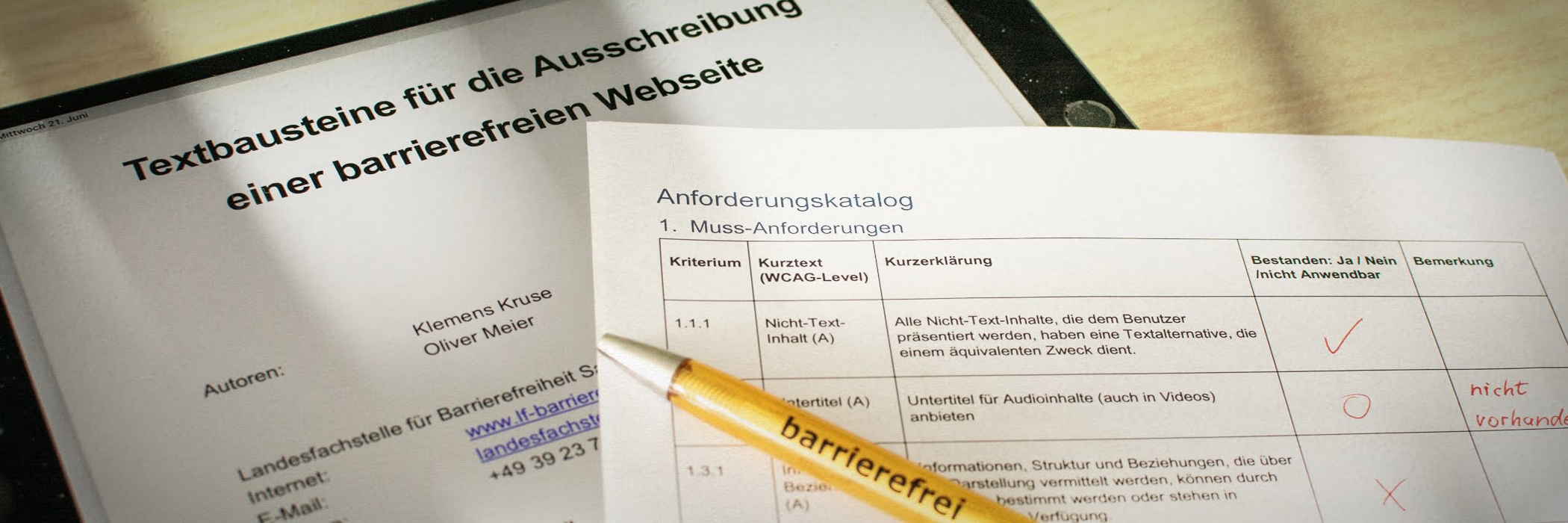 Tablet mit geöffneter Datei mit dem Titel Leitfaden für die Ausschreibung barrierefreier Webseiten. Daneben liegt der Anforderungskatalog Barrierefreiheit auf Papier gedruckt und ein Kugelschreiber mit der Aufschrift barrierefrei