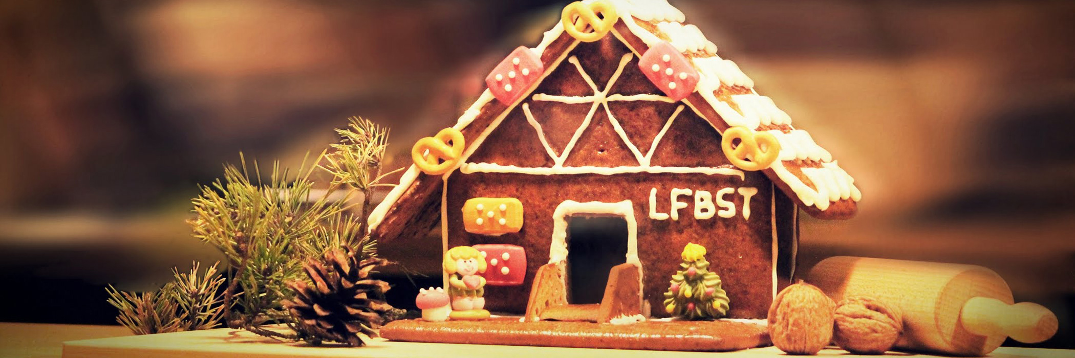 Lebkuchenhaus mit den Buchstaben LFBST am Haus steht auf einem Tisch
